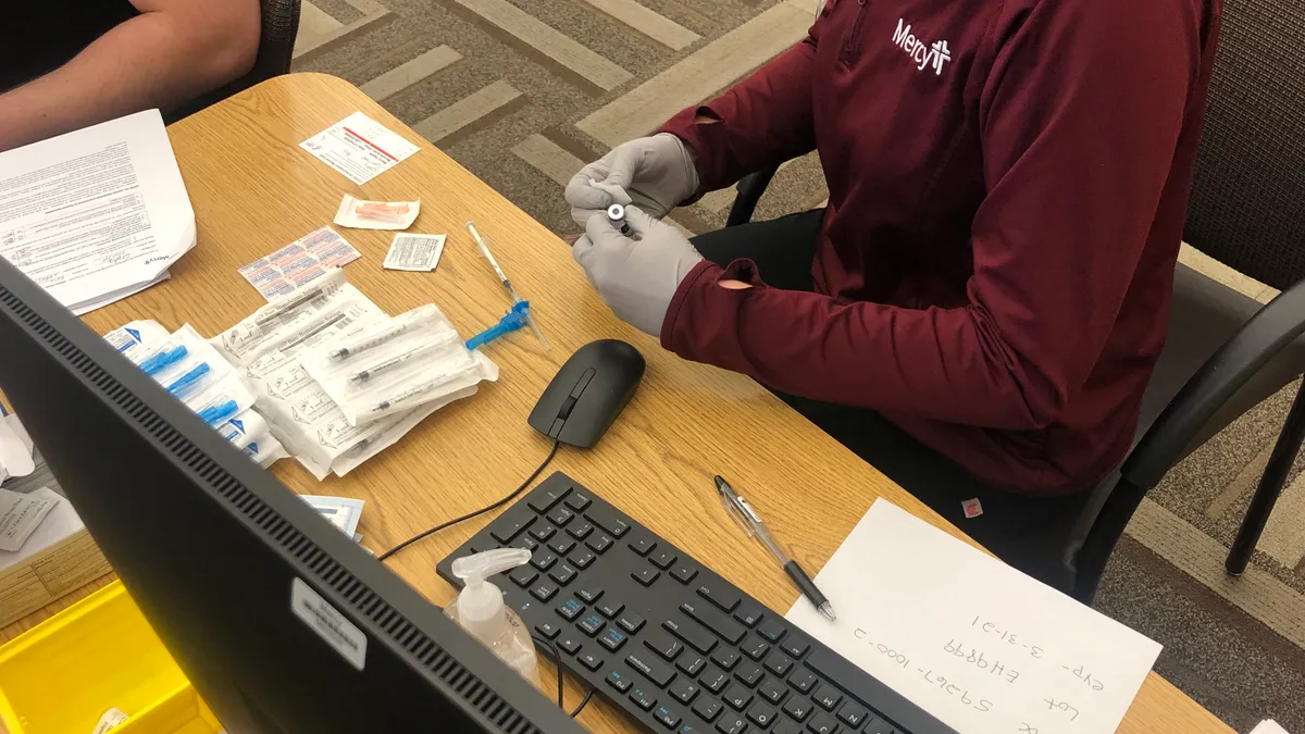 Jen Ryder, a nurse in St. Louis, prepares to administer a COVID-19 vaccine on Monday, Dec. 14. Hospitals across the country started to receive the first doses Monday.